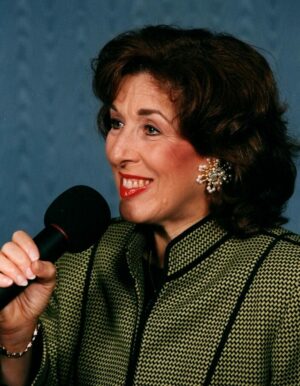 A woman holding a microphone and smiling.