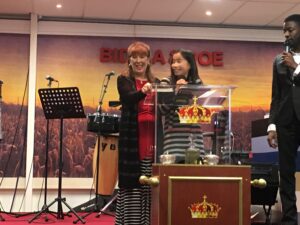 Two women standing at a podium with a microphone.