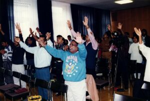 A group of people raising their hands in the air.