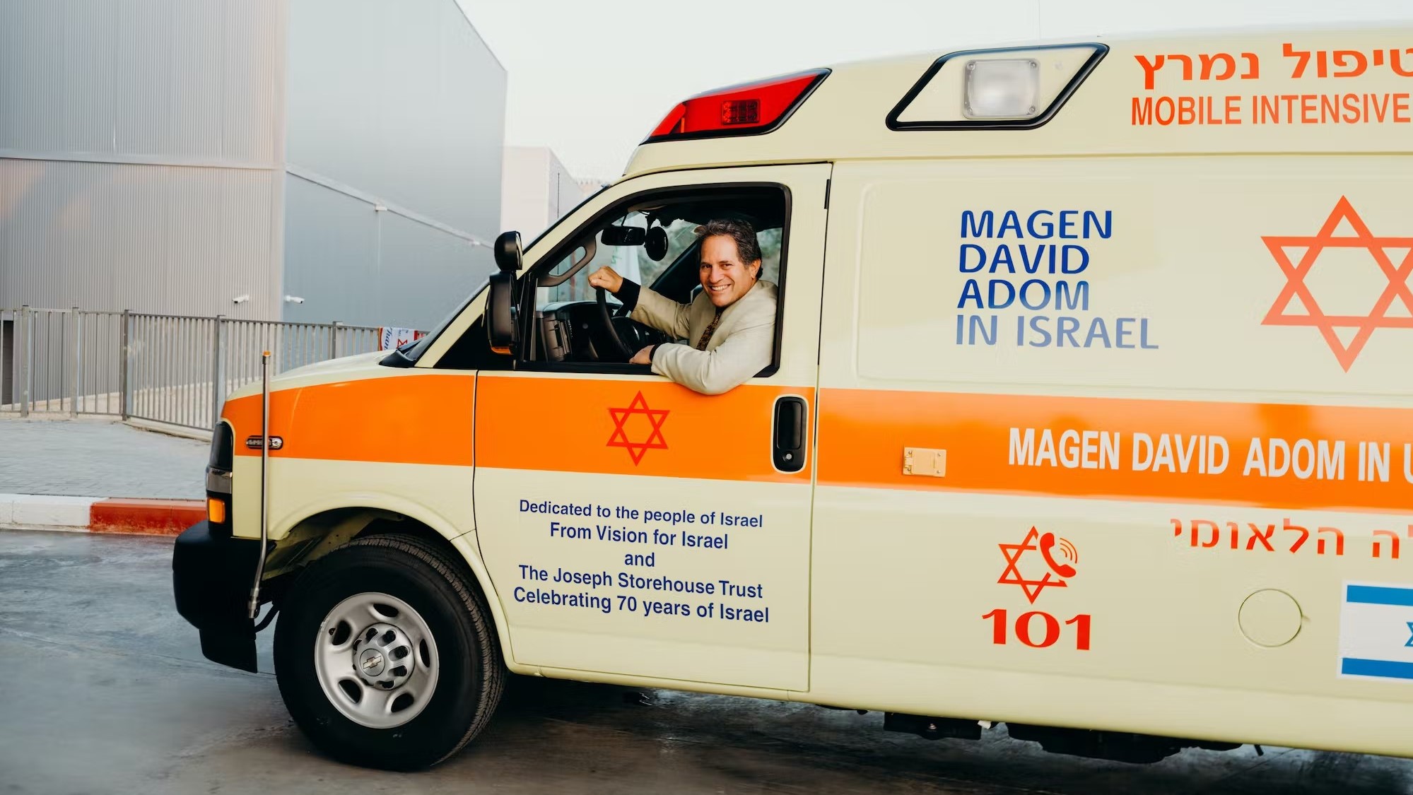 A woman sitting in the drivers seat of an ambulance.