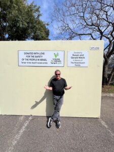 A man standing in front of a wall with some signs on it