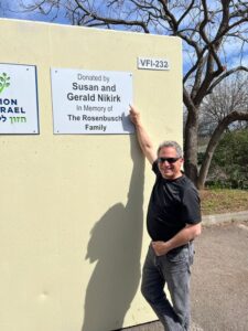 A man standing next to a wall with some signs on it