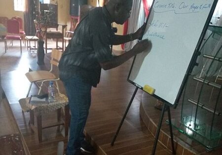 A man standing in front of a white board.