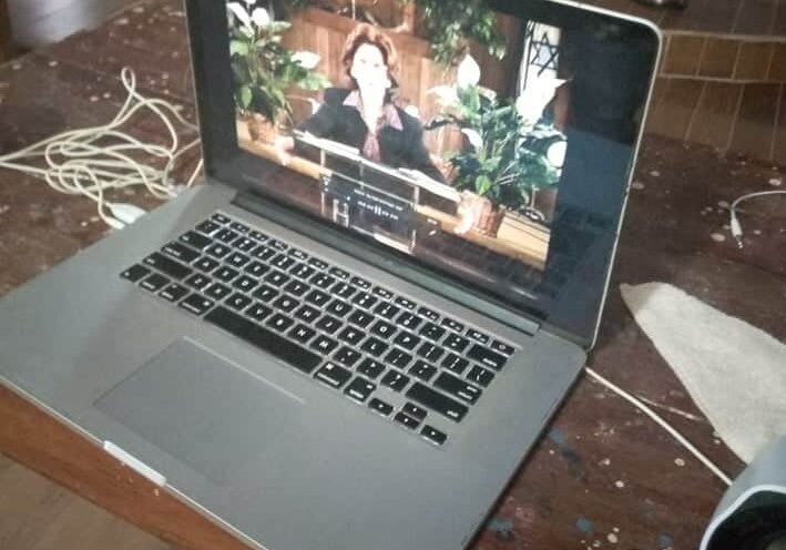 A laptop sitting on top of a wooden table.