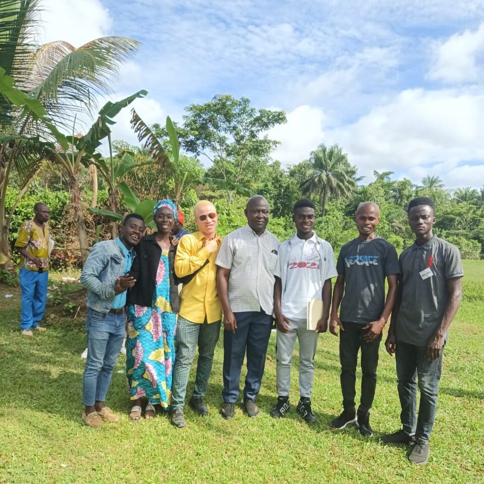 A group of people standing in the grass.